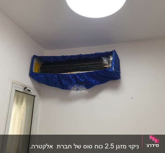מזגן מכוסה בכיסוי כחול לתחזוקה או ניקוי